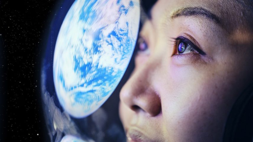 Mulher olhando imagem projetada do Planeta Terra. — Foto: O2O Creative/Getty Images
