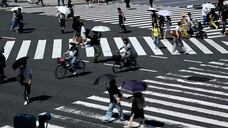 Pedestres atravessam uma rua no distrito de Ginza durante altas temperaturas em Tóquio, Japão, no verão de 2025.
