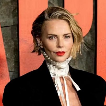 Charlize Theron aparece com blazer aberto na estreia de novo filme