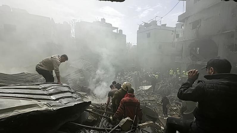 Pessoas se reúnem enquanto equipes de resgate trabalham no local de um ataque israelense na área de Jnah, em Beirute, Líbano, neste domingo