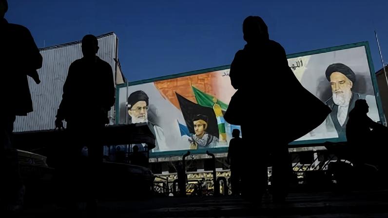 Pessoas caminham perto de um mural com imagens do líder supremo do Irã, o aiatolá Ali Khamenei, e do líder da Revolução Islâmica do Irã de 1979, o aiatolá Ruhollah Khomeini, em uma rua de Teerã, Irã, em 17 de fevereiro.