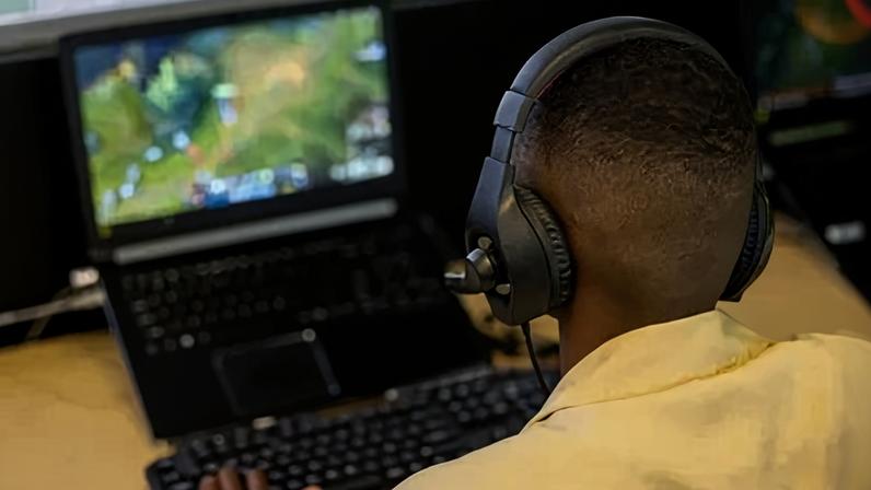 Rear view of a student studying to become a video game developer at the university - IT education concepts