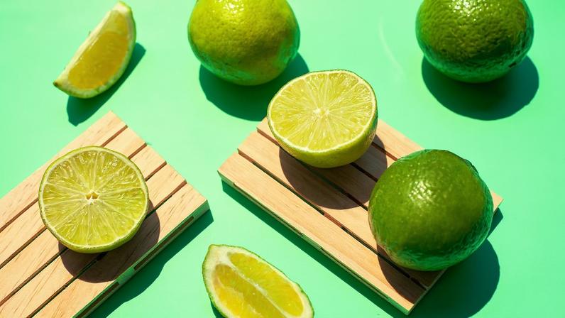 Foto colorida com fundo verde e vários limões inteiros e cortados - Como o consumo diário de água com limão favorece a saúde do organismo - Metrópoles.