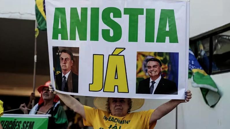Mulher segura cartaz para pedir anistia às pessoas presas e condenadas por envolvimento nos atos de 8 de Janeiro de 2023