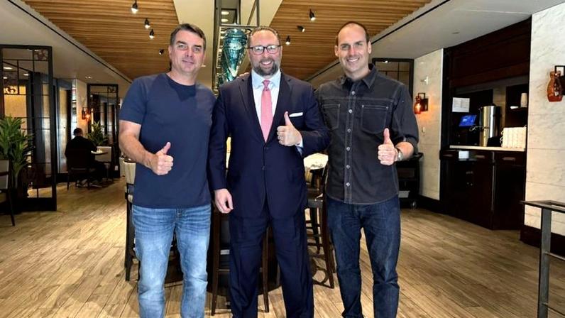 Flávio Bolsonaro (dir.) ao lado de Jason Miller e Eduardo Bolsonaro em foto compartilhada nas redes sociais