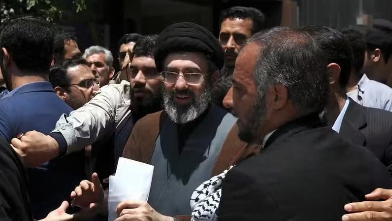 Mojtaba Khamenei é escoltado por seus seguranças no meio de multidão — Foto: Reprodução