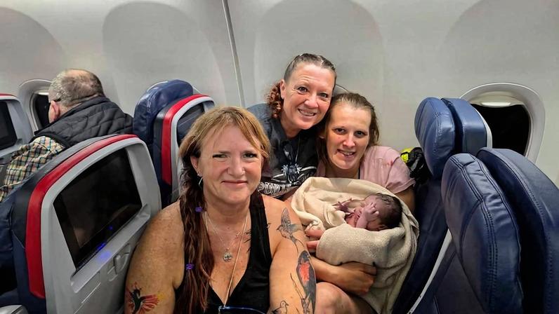 Técnicas de emergência médica Tina Fritz e Kaarin Powell com a mãe que deu à luz a bordo de avião