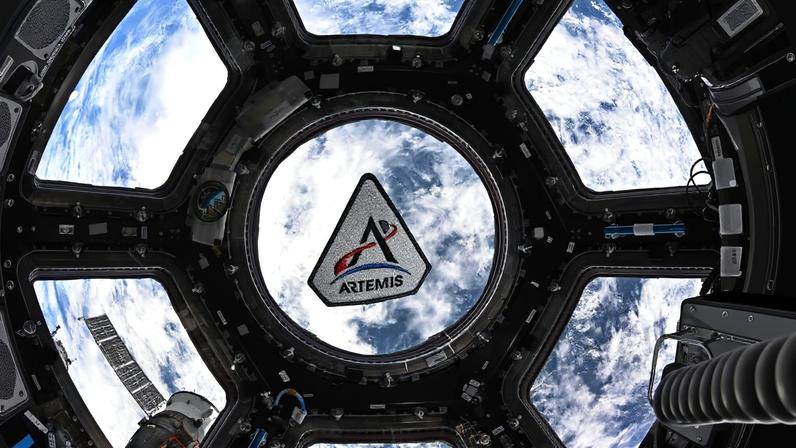 Emblema do programa Artemis flutuando na cúpula da Estação Espacial Internacional