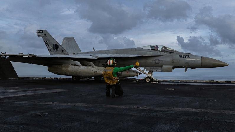 Imagem ilustrativa de um caça norte-americano no convés de voo do porta-aviões USS Abraham Lincoln (CVN 72)