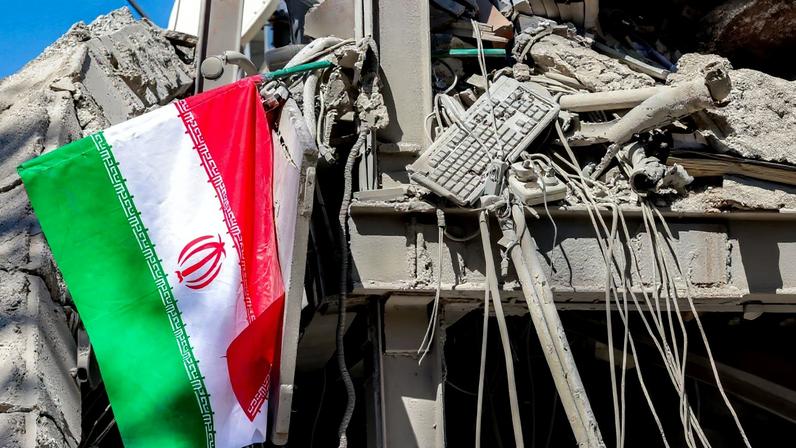 Uma bandeira nacional iraniana é colocada junto aos escombros de um prédio que desabou após ataques à Universidade de Tecnologia Sharif, em Teerã, em 7 de abril de 2026