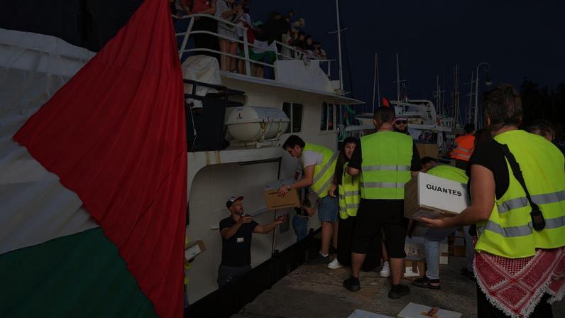 Ativistas carregam um barco antes da partida da flotilha destinada a romper o bloqueio israelense à Faixa de Gaza, na Espanha