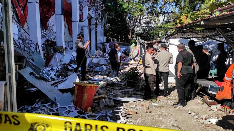 Policiais observam um prédio do Comitê Nacional de Esportes da Indonésia (KONI) do Norte de Sumatra, danificado após um forte terremoto no mar em Manado, Sulawesi do Norte, em 2 de abril de 2026.
