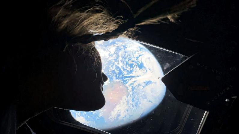 A especialista da missão Artemis II, Christina Koch, olhando para a Terra através da janela da espaçonave Orion em 2 de abril de 2026