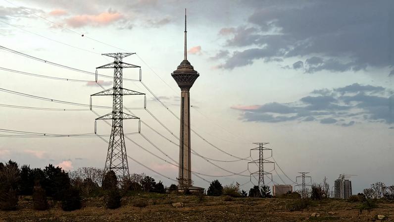 Esta foto, tirada em 4 de abril de 2026, mostra uma vista das torres de transmissão de energia e da Torre Milad ao pôr do sol em Teerã