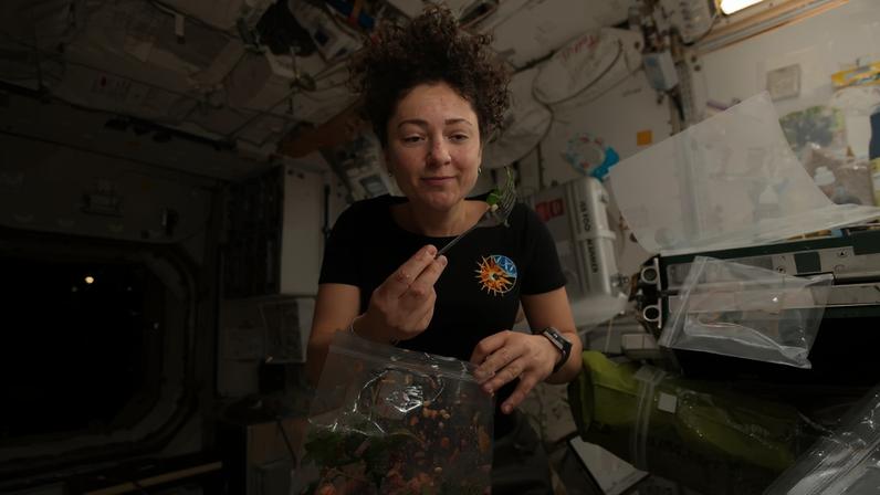 NASA astronaut Jessica Meir dines on fresh Mizuna mustard greens she harvested earlier that day aboard the International Space Station.