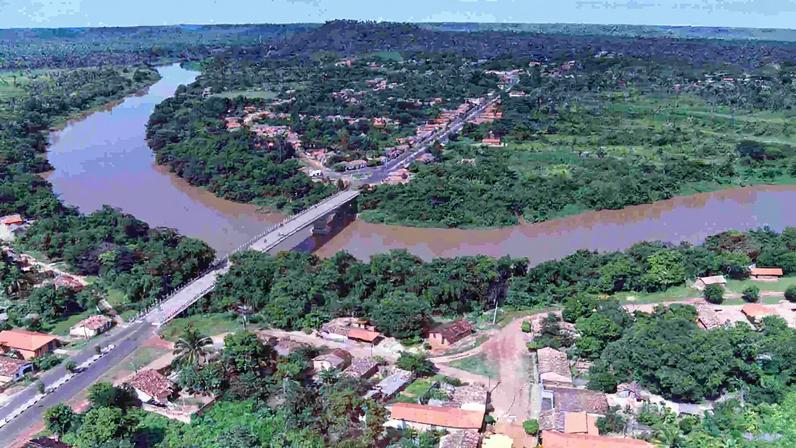 Vista aérea de São Raimundo das Mangabeiras MA, com rio, ponte e área urbana cercada por vegetação