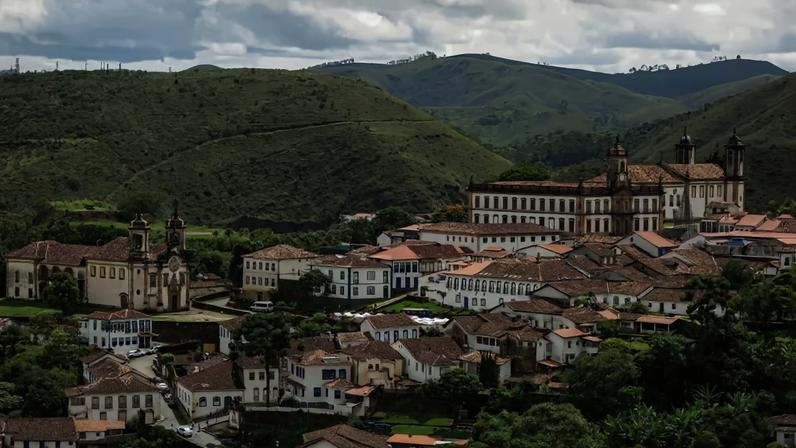 Paisagem urbana em Minas Gerais, com morros ao fundo e arquitetura de cidade média. Créditos: Quinto Andar.