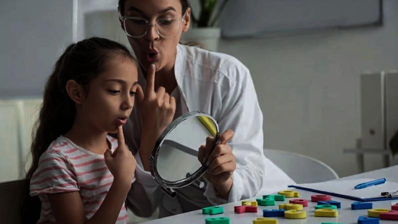 Atendimento fonoaudiológico infantil em consultório, com exercícios de articulação diante do espelho