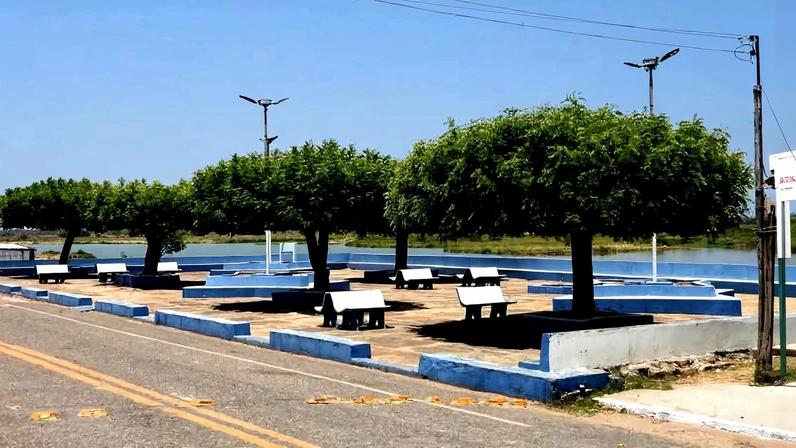 Vista de área urbana em Francisco Ayres PI, com bancos e árvores em via pública. Crédito: Portal Piracuruca.
