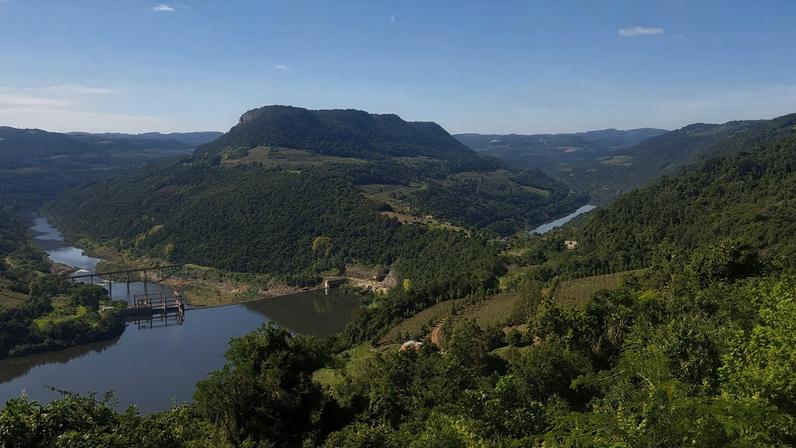 Paisagem da Serra Gaúcha com morros verdes e pequena cidade ao fundo