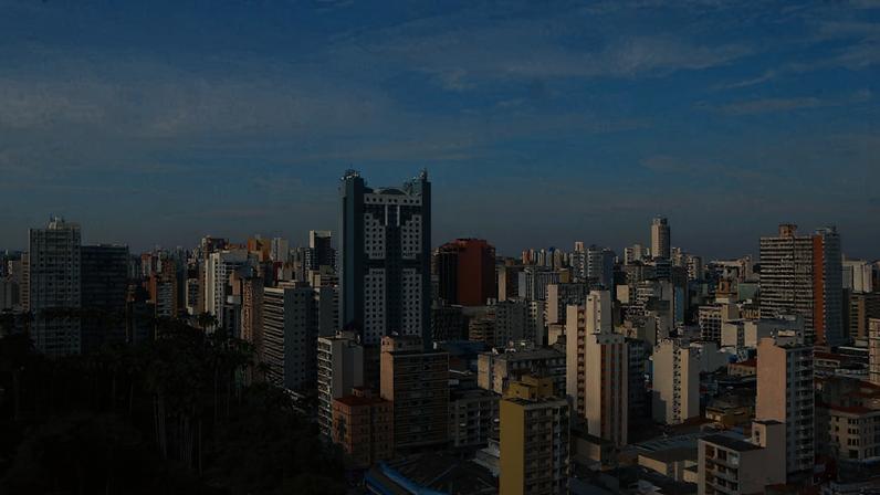 Vista panorâmica de Campinas ao entardecer, com prédios e áreas verdes