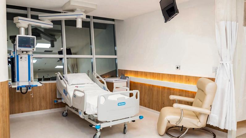 Ambiente hospitalar moderno, com leito e equipamentos, em composição horizontal