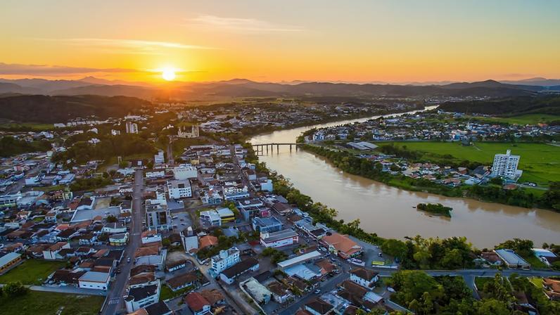 Vista aérea de Gaspar SC com o rio Itajaí-Açu ao pôr do sol.