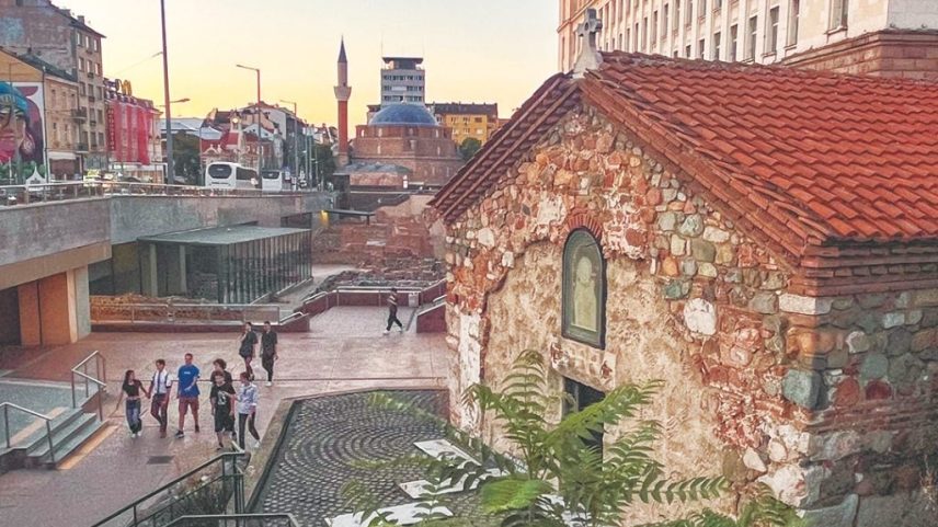 Shoppers and sightseers walk past the Church of St Petka of the Saddlers, a medieval Bulgarian Orthodox church building that stands next to Roman-era ruins in a semi-submerged mall in Sofia, Bulgaria. Behind it stands the Banya Bashi Mosque built by the Ottomans in the 1500s.