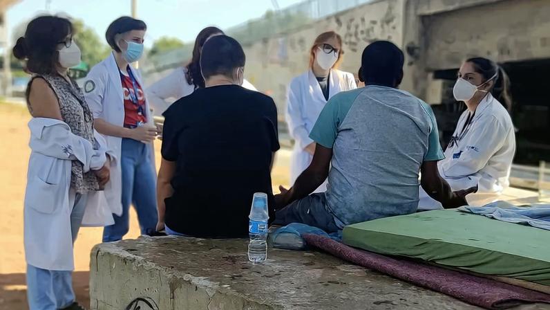 Agentes comunitários de saúde atendendo moradores em bairro de cidade pequena