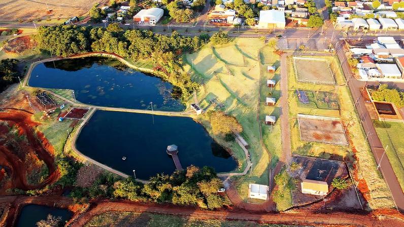 Vista aérea de cidade com lago e áreas verdes no Paraná