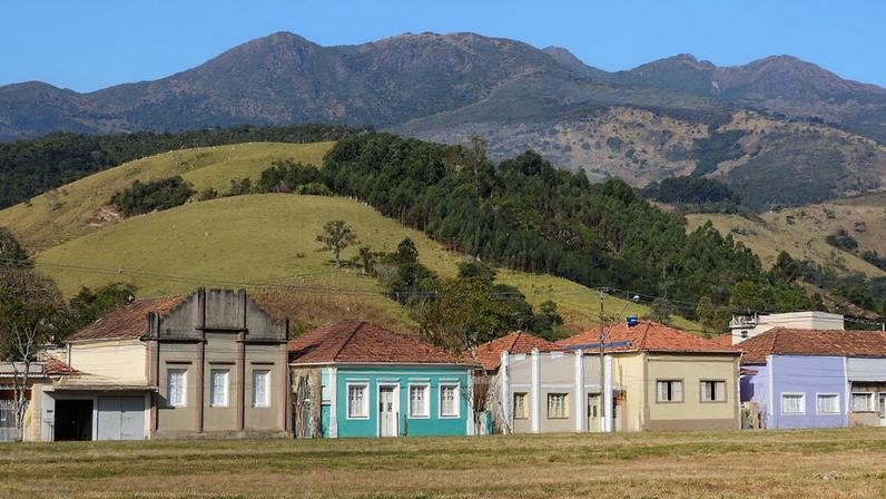 Vista urbana de Paraisópolis com casas tradicionais e a Serra da Mantiqueira ao fundo. Crédito: Conheça Minas.