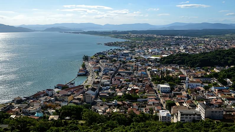 Vista da entrada da Estância Turística de São Roque, em dia claro, com vegetação e arquitetura típica. Créditos: Guia do Turismo Brasil.