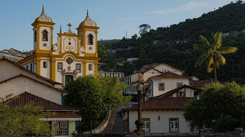 Vista urbana de Oratórios MG, com igreja e casario, em perspectiva panorâmica