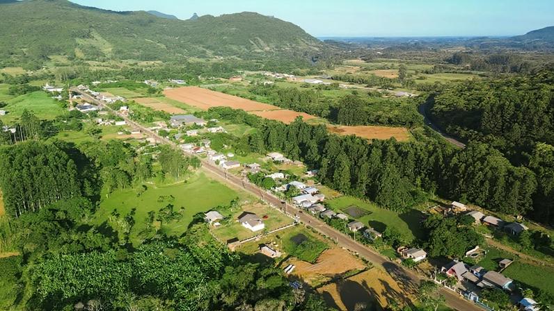 Vista aérea de pequena cidade no interior gaúcho, com campos e área urbana ao fundo