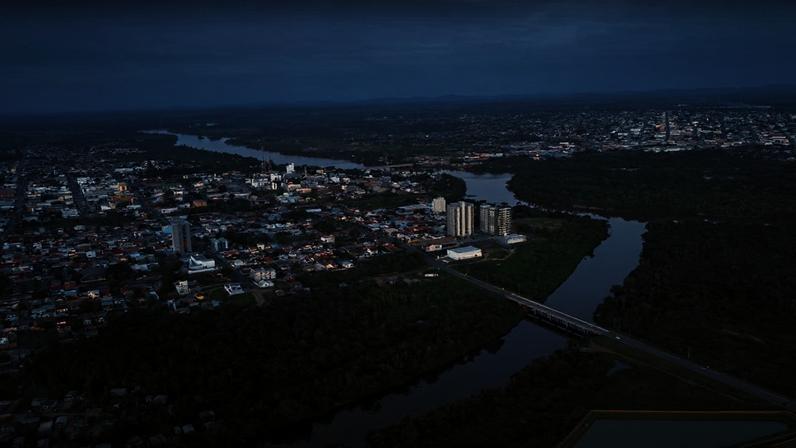Paisagem urbana em Rondônia, com rio e floresta ao fundo