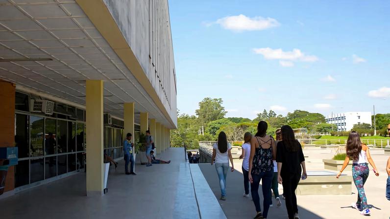 Campus da UFSM com áreas verdes e circulação de estudantes