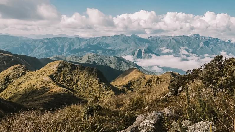 Serra da Mantiqueira vista panorâmica, com vegetação de montanha e trilhas, em dia claro