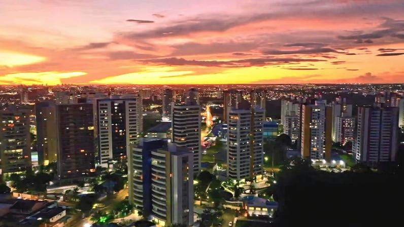 Horizonte de Manaus AM ao entardecer, com prédios iluminados e céu colorido