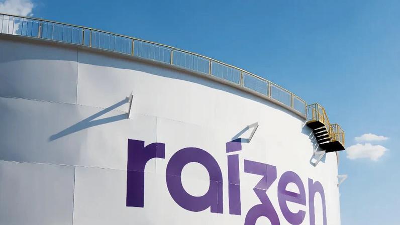 Tanque industrial branco com logotipo "raizen" em roxo, escada lateral e céu azul claro ao fundo. Investida da Cosan