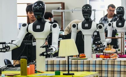 Trabalhadores são vistos treinando robôs humanoides. A foto foi tirada dentro do centro de treinamento de robôs da X-humanoid, nos arredores de Pequim, em 19 de março