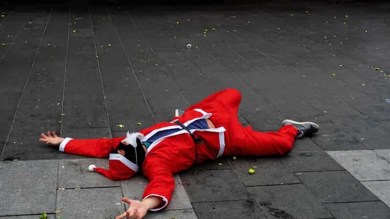 LONDON, ENGLAND - DECEMBER 08: People roll around in the street as they take part in the SantaCon 2018 on December 8, 2018 in London, England. SantaCon is an annual pub crawl featuring revellers dressed as Santa, reindeer and other Christmas icons. Originating in the United States, it has spread to several international cities, developing a reputation for rowdy crowds. (Photo by Peter Dench/Getty Images)