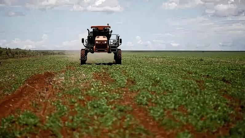 Trator espalha fertilizante em um campo de soja próximo a Brasília