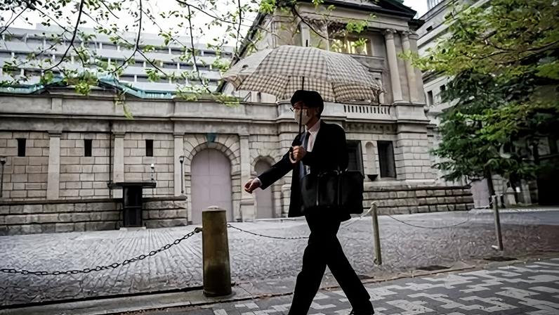 Pessoas caminham em frente à sede do Banco do Japão em Tóquio