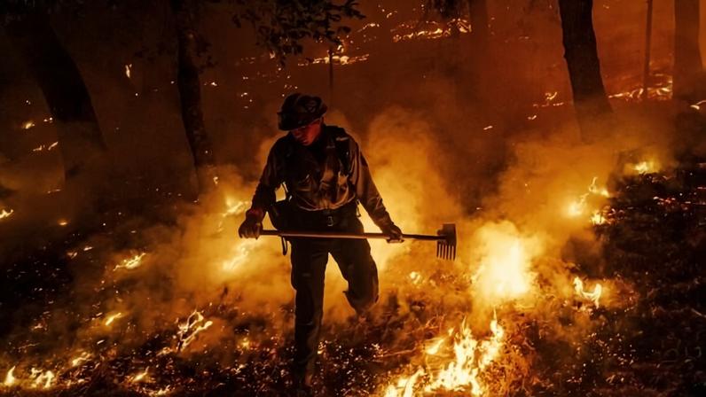 A firefighter battles the Pickett Fire burning in the Aetna Springs area of Napa County, Calif., Aug. 23, 2025. (AP Photo/Noah Berger, File)