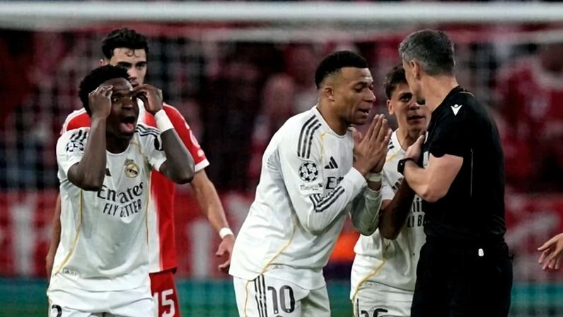 Real Madrid's Kylian Mbappe, center, and Vinicius Jr., left, disagree with referee Slavko Vincic during the Champions League quarterfinal second leg soccer match between Bayern Munich and Real Madrid in Munich, Germany, Wednesday, April 15, 2026. (AP Photo/Matthias Schrader)