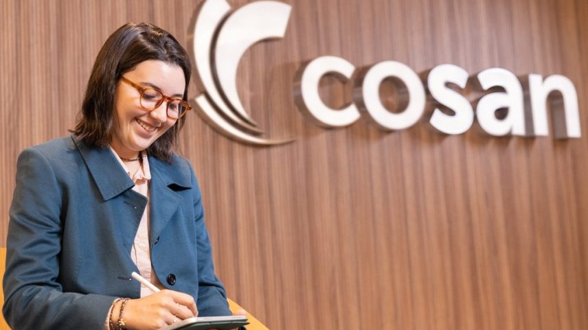 Funcionária trabalha em frente ao logo da Cosan
