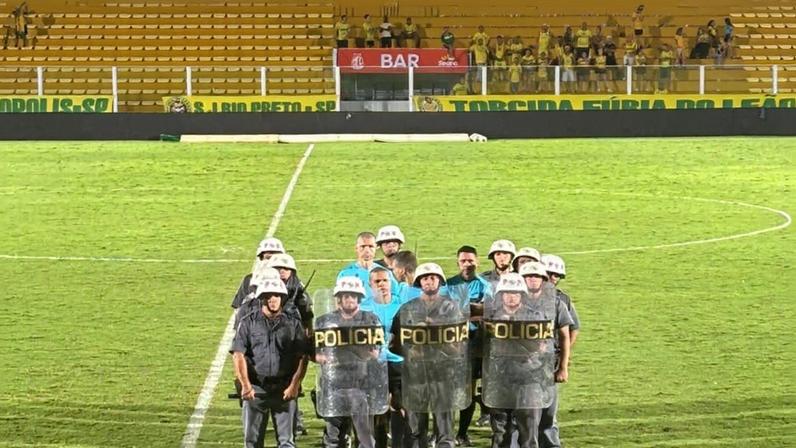 Árbitro Paulo César Zanovelli e assistentes são escoltados por policiais militares após Mirassol x Bahia — Foto: Arcílio Neto