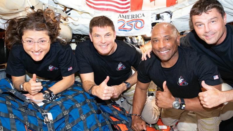 Zac Brown; (L-R) Mission Specialist Christina Koch, Mission Specialist Jeremy Hansen, Pilot Victor Glover, and Commander Reid Wiseman inside the Orion spacecraft.