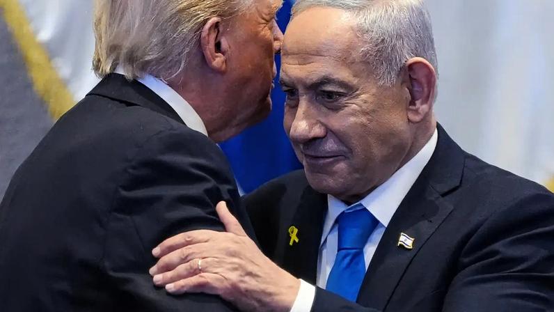 O primeiro-ministro israelense, Benjamin Netanyahu (dir.), abraça o presidente dos EUA, Donald Trump, no parlamento de Israel, o Knesset. 13/10/2025 - (Evan Vucci/AFP)