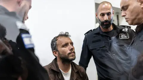 Thiago Ávila was escorted by security personnel to Tuesday's hearing in the Israeli city of Ashkelon